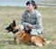 Senior Airman Tatiana Carbocci and her military working dog, 'Cuervo', a Belgian Malinois, wait during a 436th Security Forces Squadron capabilites demonstration, March 28, 2013, Dover Air Force Base, Del. Honorary Commanders, along with their military unit counterparts, received an in-depth tour of Dover AFB functional units and capabilites. (U.S. Air Force photo/Greg L. Davis)