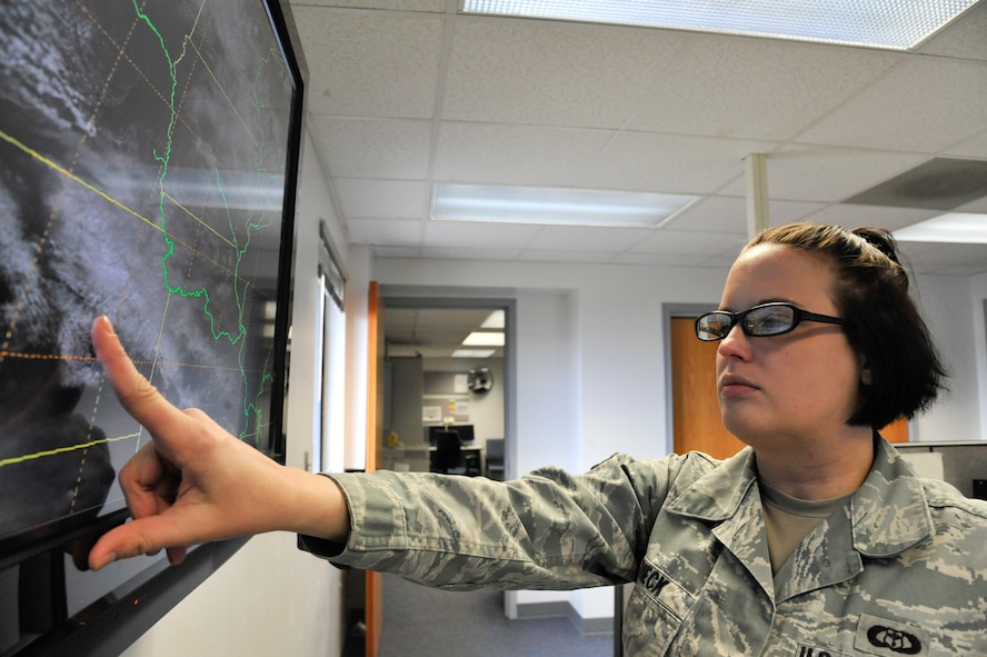 U.S. Air Force Senior Airman Heather Rieck, 509th Operation Support Squadron weather journeyman, looks at satellite pictures, Whiteman Air Force Base, Mo., March 20, 2013. Satellites send pictures from outer space to provide weather personnel with information about cloud cover and potential weather hazards that may affect the base. (U.S. Air Force photo by Airman 1st Class Keenan Berry/Released)   
