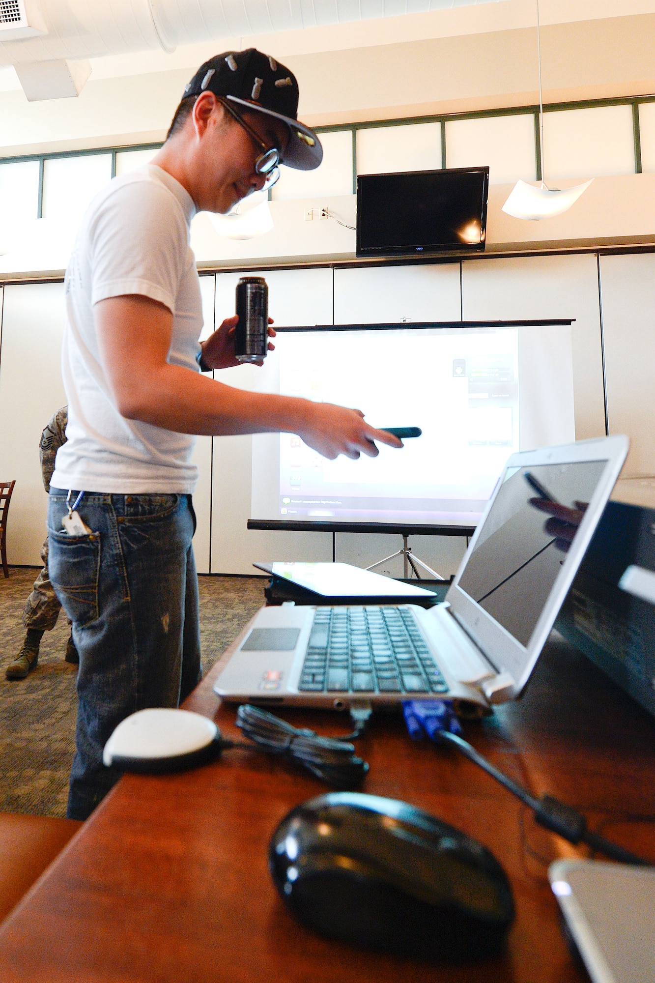 1st Lieutenant Robert Chen, 436th Communications Squadron, holds the Blackberry communication device owned by the 436th Mission Support Group commander as he demonstrates to a crowd of Honorary commanders how the 436th CS defeats hackers by using superior technology, equipment and expertly trained airman. Chen is dressed as if he were a college-aged 'hacker' and has broken in to the MSGs Commanders phone and is displaying its contents on the screen behind him. Dover has a new batch of honorary commanders who, along with their military unit counterparts, received an in-depth tour and introduction to the capabilities of Dover AFB's functional units, March 28, 2013. (U.S. Air Force photo/Greg L. Davis)