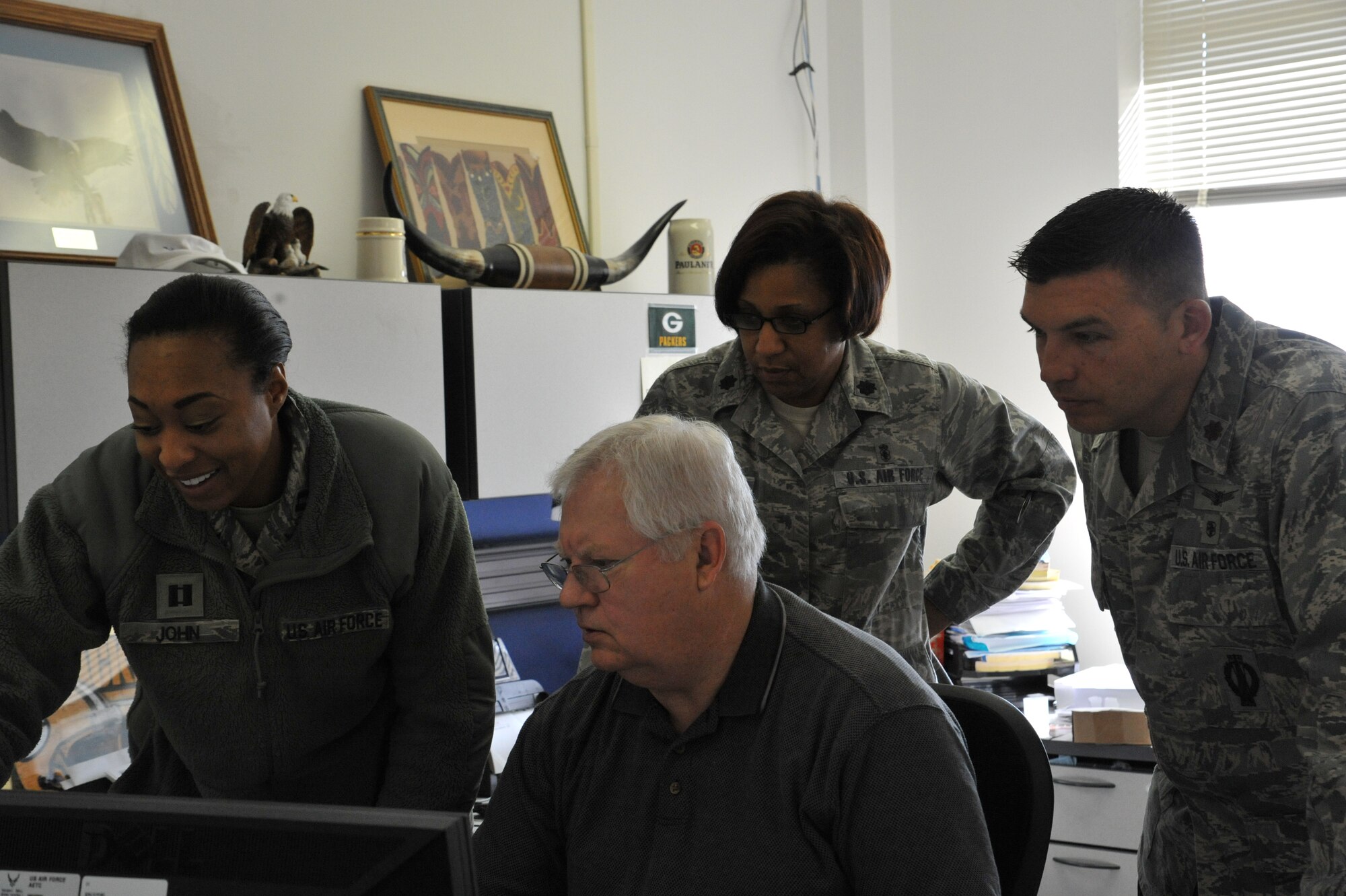 (From left to right) Capt. Marie John, Dennis Marquardt, Lt. Col. Zina Crump and Maj. Don Rousseaux examine the results of a cost-saving initiative in the 82nd Medical Group.  The campaign, which modified outpatient procedures, has saved the 82nd MDG $2.7 million in nine months.  (U.S. Air Force photo/2nd Lt. Meredith Hein)