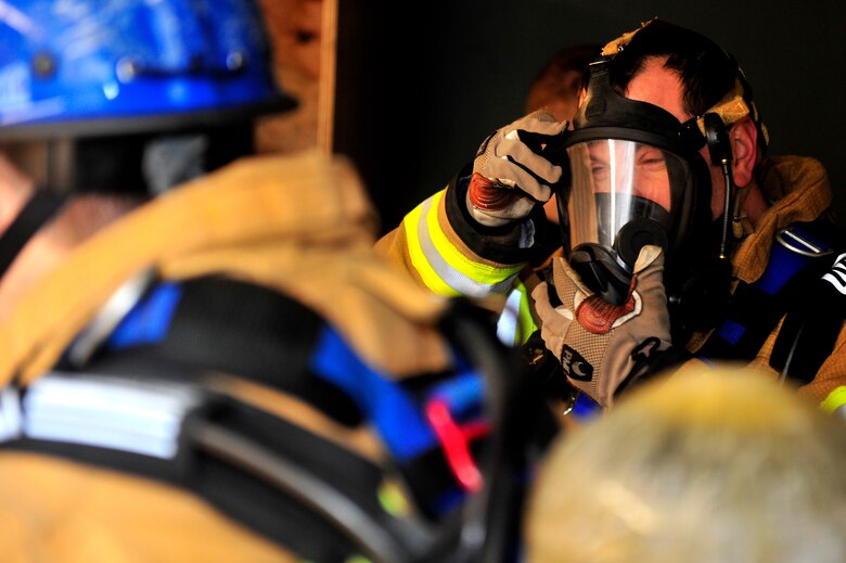 435th Civil Engineer Squadron fire fighters dawn protective gear before rescuing a mock victim during a training exercise, March 21, 2013, Ramstein Air Base, Germany. The 435th Construction Training Squadron conducted rescue technician certification training that tested 11 fire fighters in simulated rescue operations. (U.S. Air Force photo/Senior Airman Aaron-Forrest Wainwright)