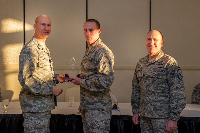 Col. Justin Davey, 628th Mission Support Group commander, and Chief Master Sgt. Al Hannon, 628th Air Base Wing command chief, present a Diamond Sharp award to Airman 1st Class Tony Chase, 628th Logistics Readiness Squadron specialized vehicle maintenance technician, during a ceremony April 2, 2013, at the Charleston Club at Joint Base Charleston - Air Base, S.C. Diamond Sharp awardees are Airmen chosen by their first sergeants for their excellent performance. (U.S. Air Force photo/ Senior Airman George Goslin)