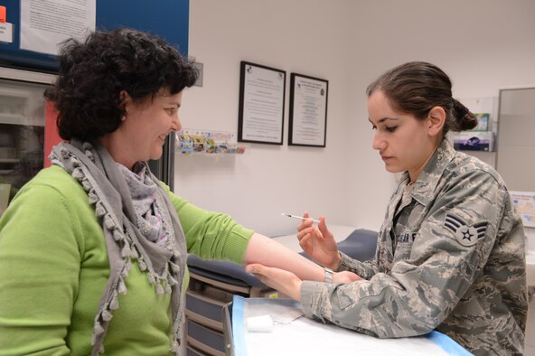 SPANGDAHLEM AIR BASE, Germany – U.S. Air Force Senior Airman Jaryl Burgoss, 52nd Medical Operations Squadron allergy immunology technician from Mooresville, N.C., provides Sabine Bettendorf, 52nd Dental Squadron with a shot, April 2, 2013. Immunizations maximize readiness and keep Airmen and families healthy. (U.S. Air Force photo by Airmen 1st Class Kyle Gese/Released)