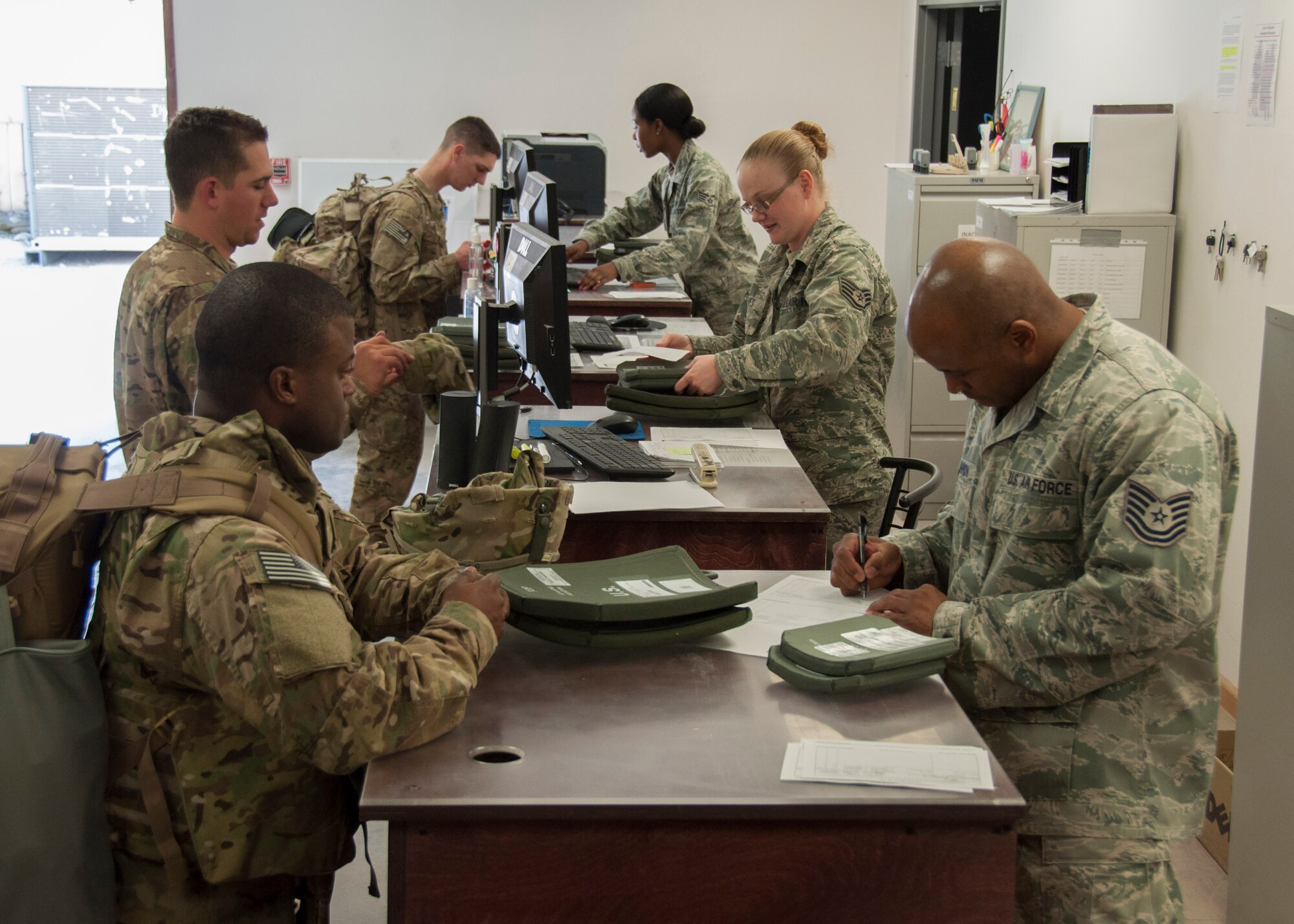 Airmen from the 376th Expeditionary Logistics Readiness Squadron's Expeditionary Theater Distribution Center issue armor plates to transient Airmen as they processes through the Expeditionary Theater Distribution Center March 29, 2013, at Transit Center at Manas, Kyrgyzstan. The armor plates, known as enhanced small arm protective inserts, are designed to protect service members from projectiles and fragmentation. (U.S. Air Force photo/Tech. Sgt. Rachel Martinez)