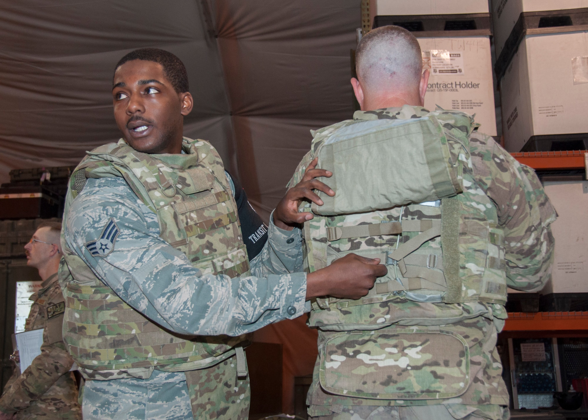 Senior Airman Antonio Walker, 376th Expeditionary Logistics Readiness Squadron, demonstrates how the individual body armor protective vest works for a group of transient Airmen during an equipment issue in the Expeditionary Theater Distribution Center March 29, 2013, at Transit Center at Manas, Kyrgyzstan. Approximately 33,500 protective vests were issued last year to Airmen deploying to Afghanistan. Walker is deployed from Holloman Air Force Base, N.M., and is a native of Selma, Ala. (U.S. Air Force photo/Tech. Sgt. Rachel Martinez)