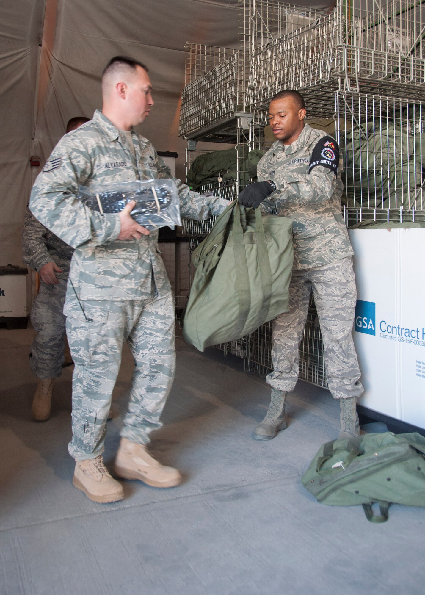 Staff Sgt. Thomas Chifunda, 376th Expeditionary Logistics Readiness Squadron, issues a C-bag to a transient Airman as he processes through the Expeditionary Theater Distribution Center March 29, 2013, at Transit Center at Manas, Kyrgyzstan. ETDC is where all deploying Airmen are issued required protective gear and equipment prior to arriving in Afghanistan. Chifunda is deployed from Ramstein Air Base, Germany, and is a native of Philadelphia, Pa. (U.S. Air Force photo/Tech. Sgt. Rachel Martinez)