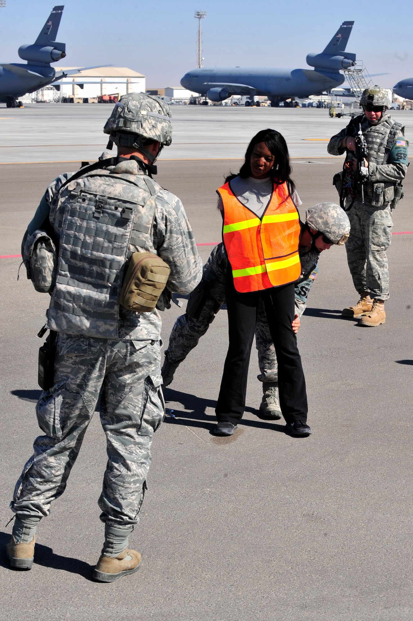 U.S. Air Force Senior Airman Amber Ricketson, 380th Expeditionary Security Forces Squadron quick response force, apprehends an intruder played by Staff Sgt. Tiffany Cooke, 380 SFS training member, while Staff Sgts. Daniel Kaltenegger and Greg Woodard, 380 SFS patrolmen, provide cover during a base defense exercise at an undisclosed location in Southwest Asia Mar. 29, 2013. The exercise objective was to test the security forces reaction-time in the event that intruders threatened Air Force assets. Ricketson is deployed from McCord Air Force Base, Wash., Cooke is deployed from Wright-Patterson AFB, Ohio and Kaltenegger and Woodard are deployed from Pennsylvania Air National Guard. (U.S. Air Force photo by Tech. Sgt. Christina M. Styer/Released) 