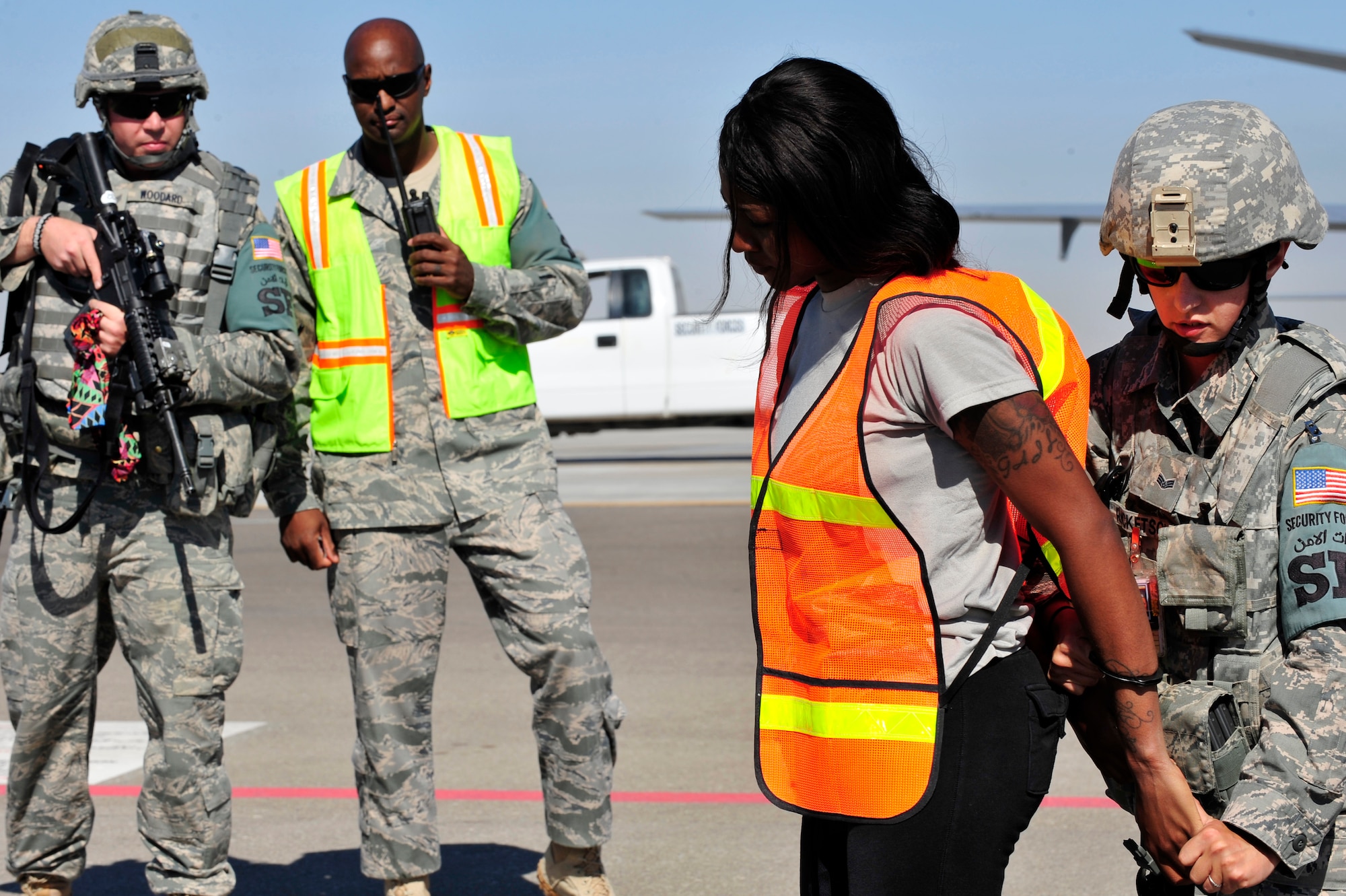 U.S. Air Force Senior Airman Amber Ricketson, 380th Expeditionary Security Forces Squadron quick response force, apprehends an intruder played by Staff Sgt. Tiffany Cooke, 380 SFS training member, while Staff Sgt. Greg Woodard, 380 SFS patrolman, provides cover during a base defense exercise at an undisclosed location in Southwest Asia Mar. 29, 2013. Exercise evaluators tested and evaluated the security forces reaction-time in the event that intruders threatened Air Force assets. Ricketson is deployed from McCord Air Force Base, Wash., Cooke is deployed from Wright-Patterson AFB, Ohio and Woodard is deployed from Pennsylvania Air National Guard. (U.S. Air Force photo by Tech. Sgt. Christina M. Styer/Released) 
