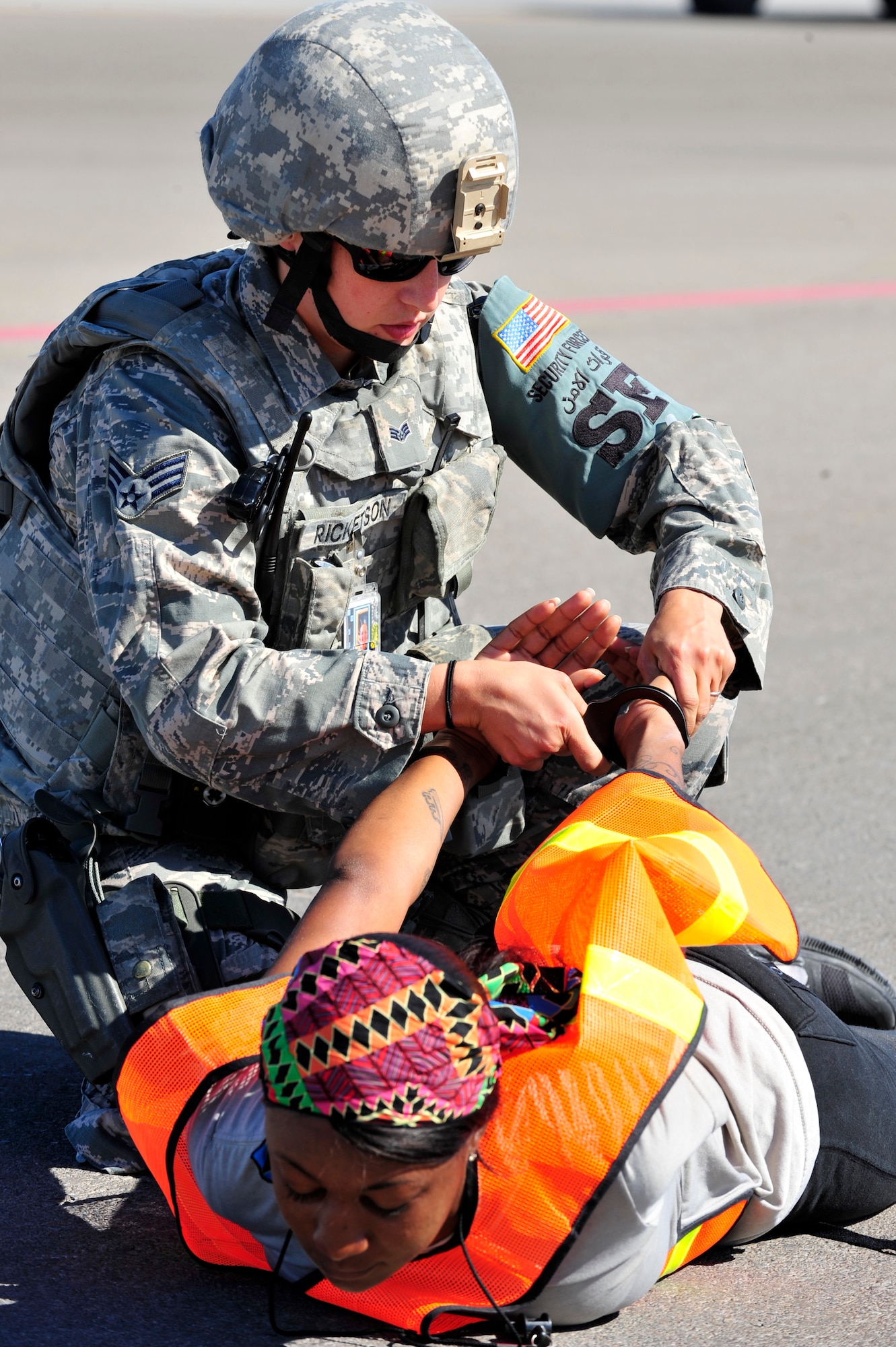 U.S. Air Force Senior Airman Amber Ricketson, 380th Expeditionary Security Forces Squadron quick response force, apprehends an intruder played by Staff Sgt. Tiffany Cooke, 380 SFS training member, during a base defense exercise at an undisclosed location in Southwest Asia Mar. 29, 2013. The exercise objective was to test the security forces reaction-time in the event that intruders threatened Air Force assets. Ricketson is deployed from McCord Air Force Base, Wash. and Cooke is deployed from Wright-Patterson AFB, Ohio. (U.S. Air Force photo by Tech. Sgt. Christina M. Styer/Released) 