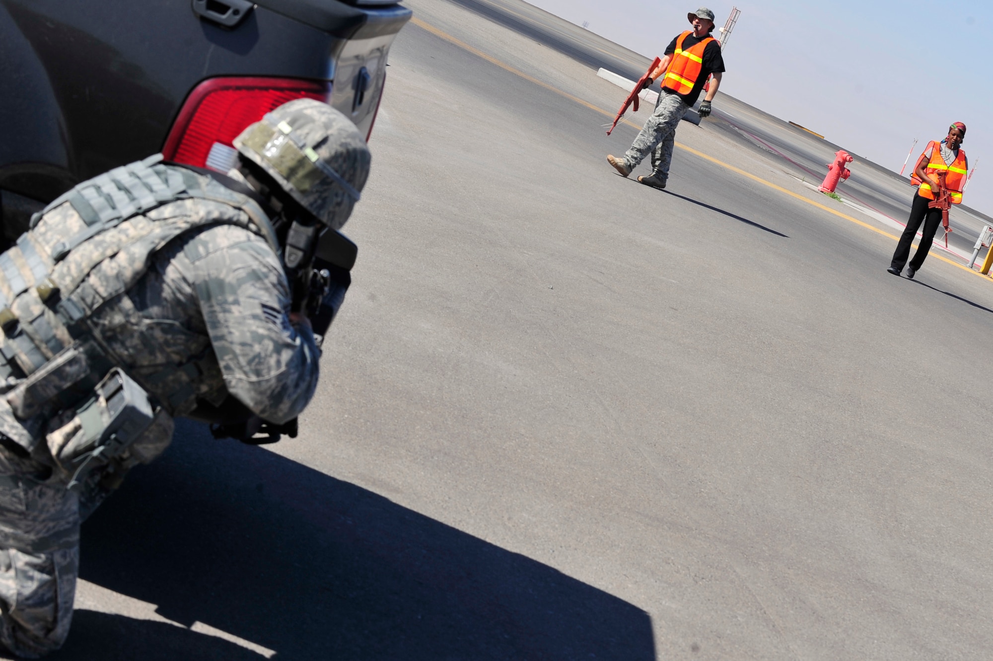 A patrolman assigned to the 380th Expeditionary Security Forces Squadron takes a defensive posture while intruders attempt to infiltrate the flightline during a base defense exercise at an undisclosed location in Southwest Asia Mar. 29, 2013. The exercise objective was to test the security forces reaction-time in the event that intruders threatened Air Force assets. (U.S. Air Force photo by Tech. Sgt. Christina M. Styer/Released)  