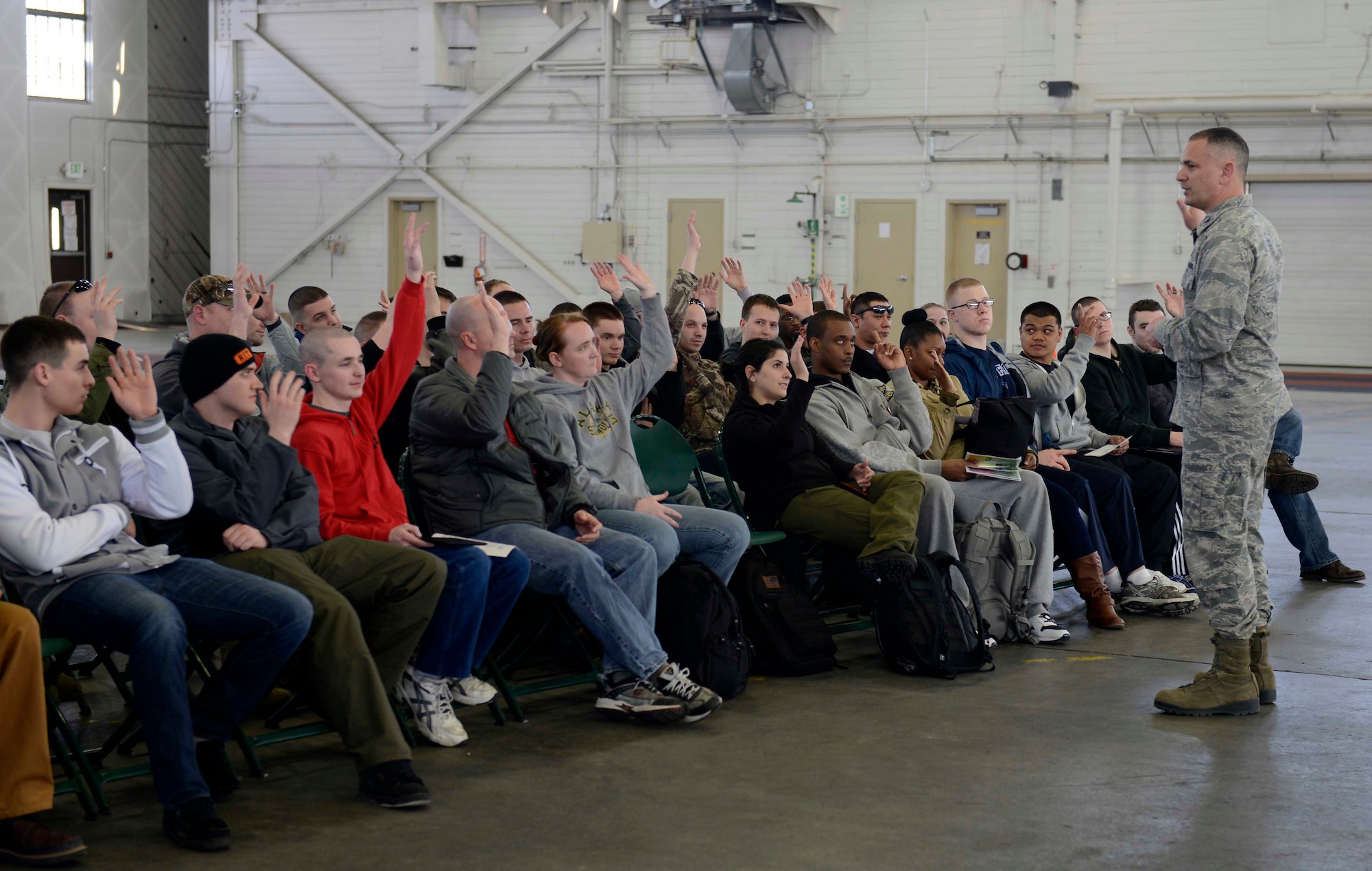 Air Force Col. Frank Battistelli briefs simulated evacuees during a Noncombative Evacuation Operation Exercise at Hangar 5 on Joint Base Elmendorf-Richardson during Polar Force 13-3 April 1. The exercise is designed to test military readiness in the event of a natural disaster or military conflict. (U.S. Air Force photo by Tammie Ramsouer)