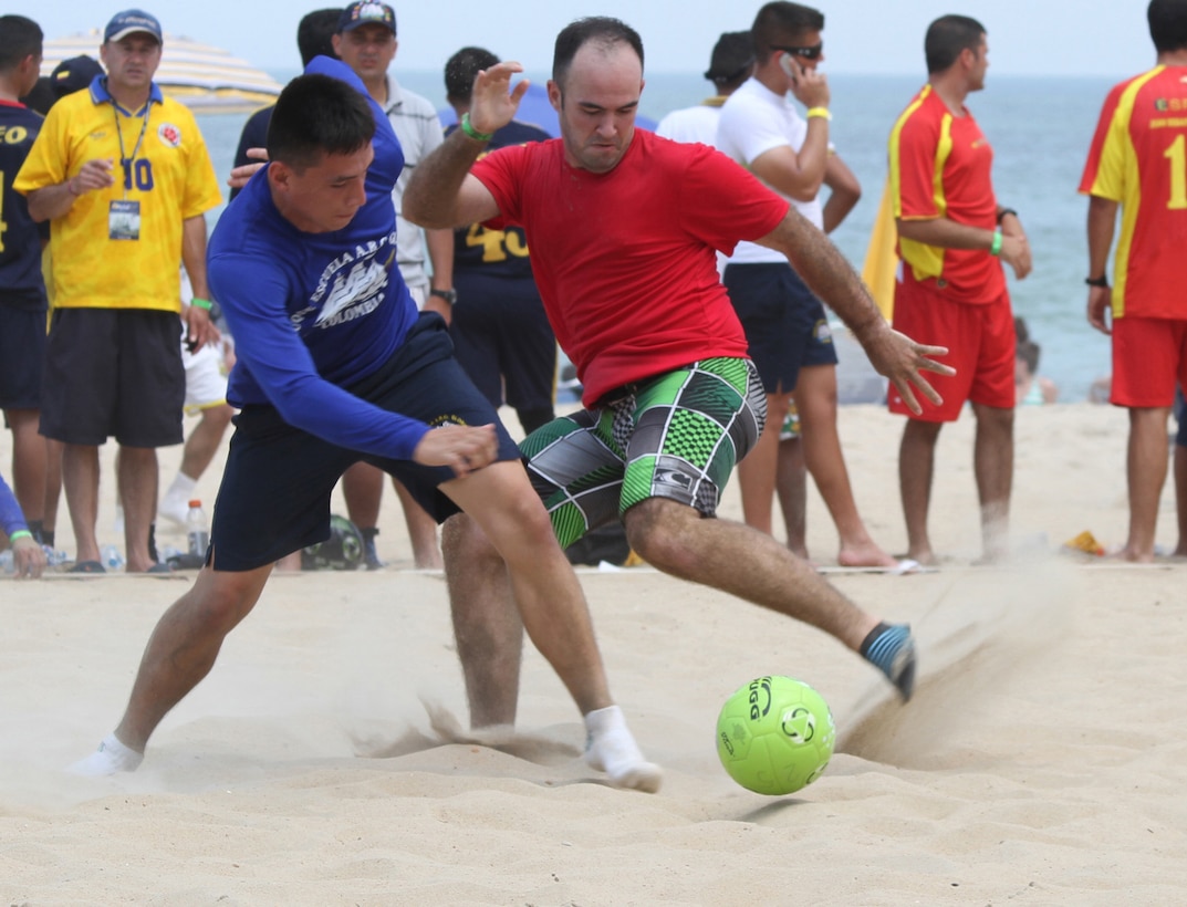 Antonio Pazos and a Colombian navy sand soccer player each try to take control of the ball during a sand soccer tournament last year. When Pazos isn’t working he keeps himself busy with soccer, sand soccer, tennis and cheering for his favorite baseball and football team with friends. Last year he was on the Corps Kickers, a sand soccer team in the international military division tournament. They played their fourth and final match against a Colombian navy team and lost 6-2 during the OpSail 2012 event. Although sand soccer has been a part of OpSail since 1994, this was the first year an international military division was included. According to Norfolk Festevents, the popularity of this division was overwhelming and it will be included in the future. (U.S. Army photo/Pamela K. Spaugy)