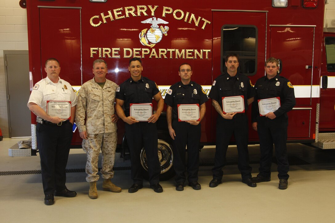 Col. Philip J. Zimmerman, commanding officer of Marine Corps Air Station Cherry Point, stands with the five Lifesaving Award recipients on Cherry Point, N.C., March 27. (From left to right) Assistant chief Nicholas Salter, Col. Philip J. Zimmerman, firefighter Raymond Bane, paramedics Mengamin Leither and Michael Spencer, and firefighter Clayton Turner.