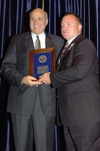 Army National Guard Sgt. 1st Class Leland Hughes (right) is awarded the General E. R. Quesada Memorial Award by Air Traffic Control Association Chairman Neil R. Planzer during an awards luncheon in Washington Oct. 29 for his ATC duties under war-time conditions in Iraq.