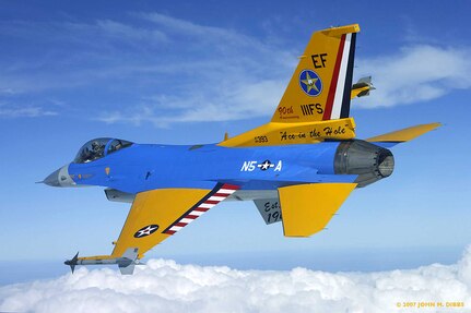 An F-16C Fighting Falcon from the Texas Air National Guard's 111th Fighter Squadron flies with a special paint job in honor of the squadron's 90th anniversary. All the colors and markings have specific meanings, reflecting the unit's nine-decade history. The rudder is painted like a JN-4 Jenny, which the squadron flew in the 1920s. The schemes for the wings and flaps recall the paint schemes of the pre-World War II era. The blue fuselage represents the Korean War, in which the squadron earned credit for two air victories. The gray underside represents the jet age. The "N5 A" was the insignia the squadron's P-51 Mustangs sported during World War II, in which the squadron claimed 44 air victories. Also representing World War II is the star on the fuselage, while the star on the wing represents the pre-World War II era. "Ace in the Hole" and the star on the tail replicate the markings of the squadron's F-84s during the Korean War. The ventral fin, partially obscured, reads "Est. 1917." Today the 111th FS is part of the 147th Fighter Wing, based on Ellington Field in Houston.