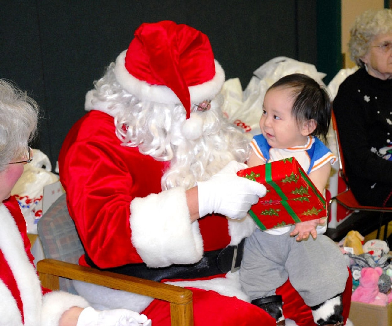 Richard Nashoalook of Wainwright, Alaska, smiles as he receives a gift from Santa Claus during Operation Santa Claus Nov. 26. The Alaska National Guard program delivers school supplies, presents and Santa Claus and Mrs. Claus to rural villages across the state.