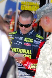 National Guard NASCAR driver, Casey Mears signs an autograph for the Arizona National Guard's 2007 NCO of the Year, Sgt. Frank Ledesma, Nov. 11, during the Checkers Auto Parts 500 at the Phoenix International Raceway.