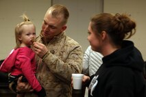Sgt. Robert Sampson, a technician with 2nd Explosive Ordnance Disposal Company, 8th Engineer Support Battalion, feeds his daughter during a going-away ceremony aboard Camp Lejeune, N.C., March 28, 2013.  Sampson and other technicians lingered around the building waiting for the buses to arrive to take them on their latest journey – to Afghanistan. 
