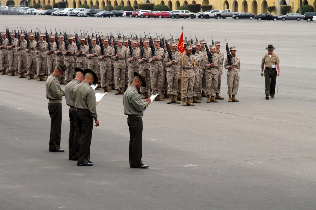 Staff Sgt. Michael J. Serritos, senior drill instructor, Platoon 2127, Company F, 2nd Recruit Training Battalion, walks over to take his place near the front of the platoon while drill masters prepare to grade the next drill movement during final drill aboard Marine Corps Recruit Depot San Diego March 18. 