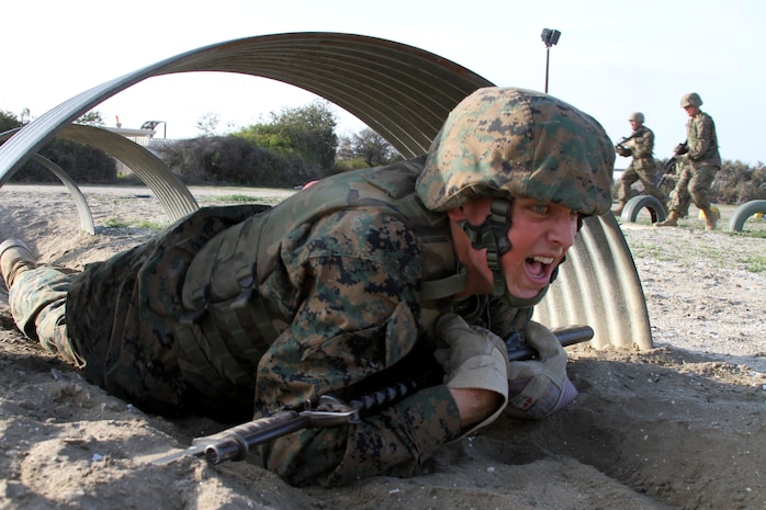 A recruit from Company L, 3rd Recruit Training Battalion, low crawls during the Bayonet Assault Course aboard Marine Corps Recruit Depot San Diego March 19. During part of the BAC, recruits attach bayonets to their rifles and simulate hand-to-hand combat with plastic dummies.