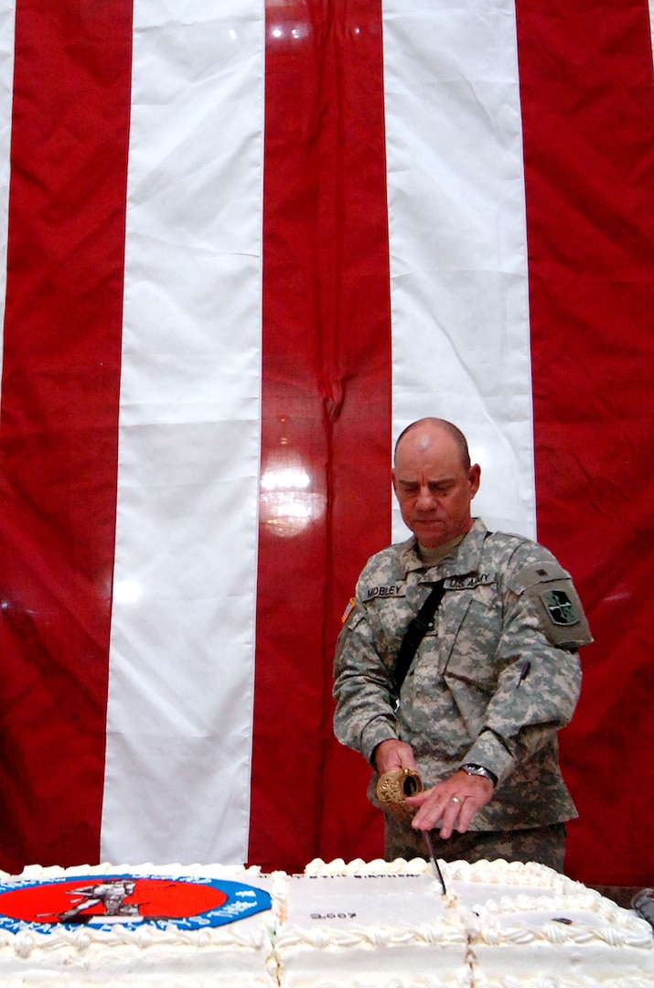 Master Sgt. Clarence Mobley, of the 58th Infantry Brigade Combat Team, cuts the birthday cake during celebrations of the National Guard's 371st birthday at the Al Faw palace at Camp Victory, Iraq, Thursday, Dec. 13, 2007. Mobley, the oldest National Guard servicemember in attendance,has served in both Vietnam as well as the current conflict in Iraq. Celebrations at Camp Victory included representatives from both the oldest National Guard unit as well as the youngest.