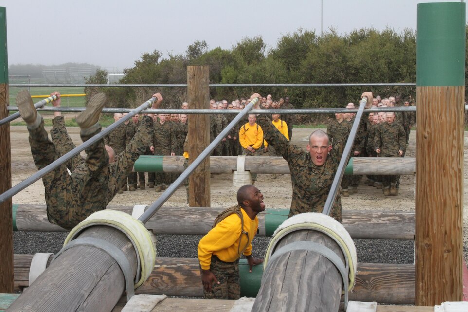 Recruits of Company H, 2nd Recruit Training Battalion, attempt to complete the sliding bar portion of the obstalce course aboard Marine Corps Recruit Depot San Diego March 14. Drill instructors teach recruits two methods to navigate across using either one or two bars. 