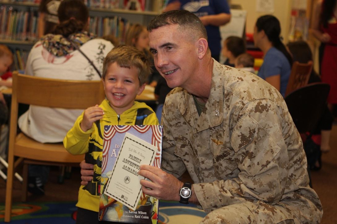 Wyatt, 3, and Col. John Farnam, commanding officer of Marine Corps Air Station Miramar, Calif., pose for a photo in the MCAS Miramar Children's Library, April 2, 2013. The "Tell Me a Story" event was part of the "Month of the Military Child." Events are scheduled to continue until the end of April.