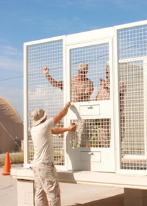 Air Force Staff Sgt. Kevin Gordon, Senior Master Sgt. Patrick Obrien and Senior Airman Kevin Green construct a special cell, Dec. 27, 2007, that will be used to hold detainee witnesses during military commissions. This is one of many new features of the Expeditionary Legal Complex. JTF Guantanamo conducts safe and humane care and custody of detained enemy combatants. The JTF conducts interrogation operations to collect strategic intelligence in support of the Global War on Terror and supports law enforcement and war crimes investigations. JTF Guantanamo is committed to the safety and security of American service members and civilians working inside its detention facilities.