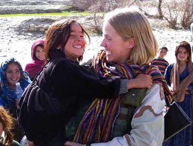 Utah Army National Guard Sgt. Jill Stevens, who is competing in the Miss America pageant as Miss Utah, plays with children while serving as a medic in Afghanistan in 2004.