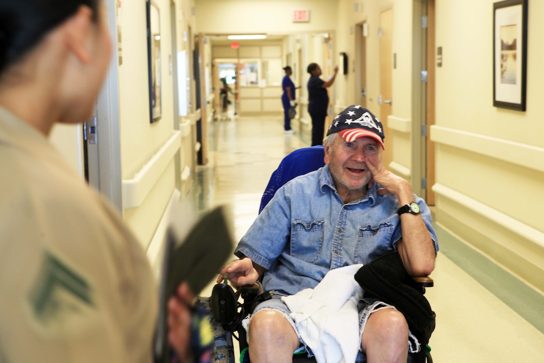 Marine Korean war veteran, Tommy Moreau, approaches a group of Marines and sailors waiting for him outside his room at the Southeast Louisiana War Veterans’ home, March 28, 2013.  Many veterans at the home do not get visitors often and appreciate when service members come to visit them.