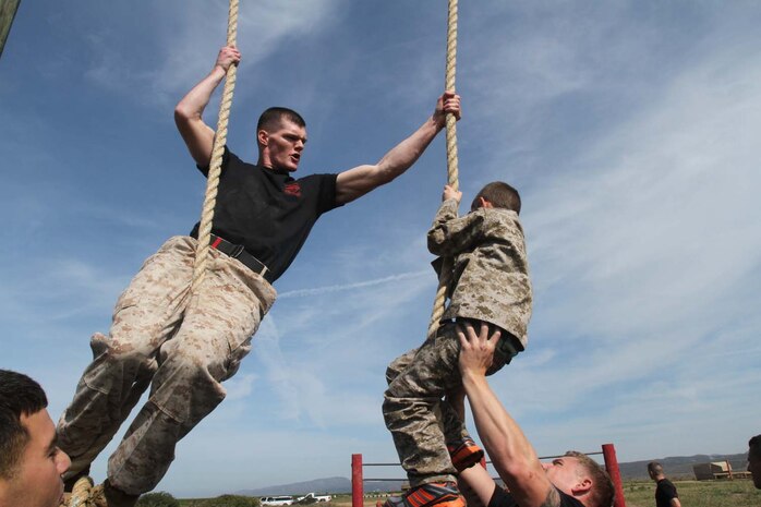 Staff Sgt. Keith Becker, a martial arts instructor trainer serving with Weapons Field Training Battalion, climbs a rope with Justin Sekili, an 8-year-old native of Green Oaks, Ill., during a visit to Edson Range here, March 28, 2013. Sekili has a heart defect that required him to undergo multiple open-heart surgeries. The Make-A-Wish Foundation helped Sekili achieve his wish of becoming a Marine for a day. Becker, a 26-year-old native of Long Island, N.Y., said it was inspiring to see a young kid giving his all to impress the Marines and a great experience to spend time with Sekili. (Official Marine Corps photo by Lance Cpl Dabney)