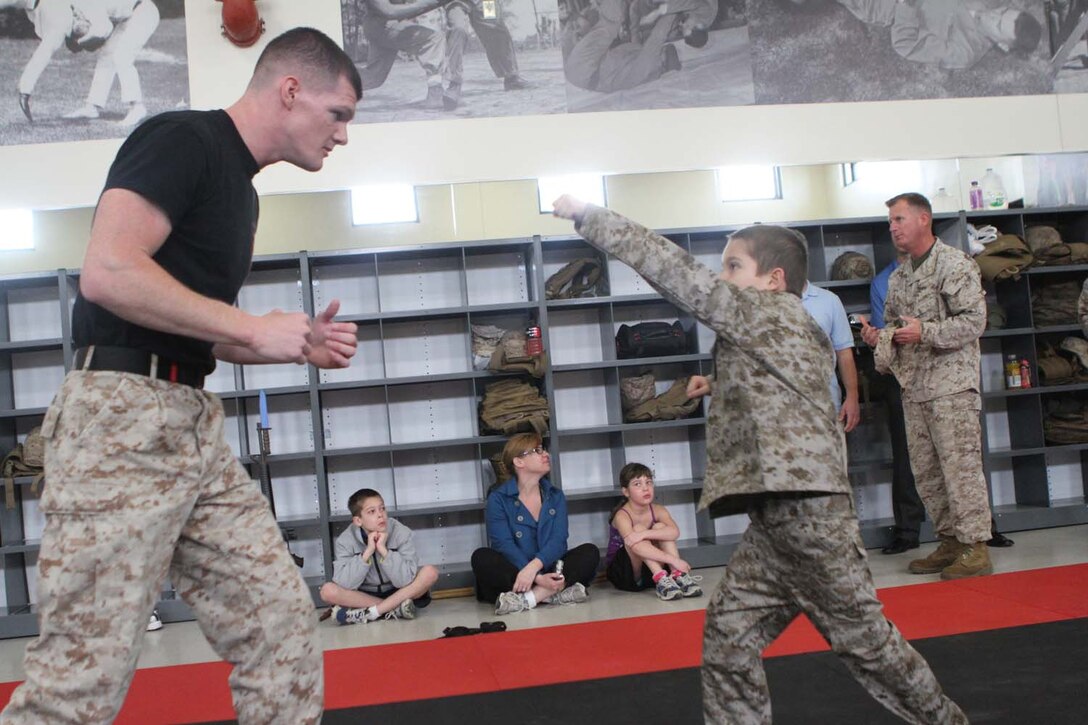Staff Sgt. Keith Becker, a martial arts instructor trainer serving with Weapons Field Training Battalion, teaches Justin Sekili, an 8-year-old native of Green Oaks, Ill., the proper way to throw a rear hand punch during a visit to Edson Range here, March 28, 2013. The Make-A-Wish Foundation helped Sekili achieve his wish of becoming a Marine for a day. Sekili has a heart defect that requires him to undergo multiple open-heart surgeries. Becker, a 26-year-old native of Long Island, N.Y., said Sekili quickly picked up basic Marine Corps Martial Arts Program techniques. (Official Marine Corps photo by Lance Cpl Dabney)