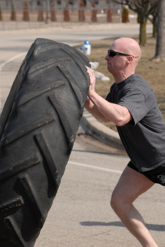 U.S. Air Force Staff Sgt. and Tactical Air Control Party specialist Nathan Adams flips a 230 pound tractor tire across the final lap of the TACP Association 24 Hour Run Challenge at the 182nd Airlift Wing in Peoria, Ill., March 29, 2013.  Sixty-two runners ran 161.75 miles around the installation over the course of 24 hours and raised over $8,200 in support of the TACP community and their families.  The 182nd team also ran in remembrance of Staff Sgt. Jacob Frazier, a member of the Peoria-based 169th Air Support Operations Squadron who was killed in action near Geresk, Afghanistan, exactly 10 years earlier.  (U.S. Air Force photo by Staff Sgt. Lealan Buehrer//Released)(This image was cropped to emphasize the subject of the image.)