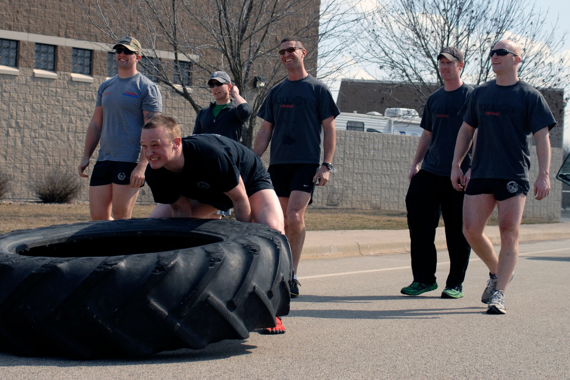U.S. Air Force Senior Airman Nicolas Menz and fellow Tactical Air Control Party specialists flip a 230 pound tractor tire across the final lap of the TACP Association 24 Hour Run Challenge at the 182nd Airlift Wing in Peoria, Ill., March 29, 2013.  Sixty-two runners ran 161.75 miles around the installation over the course of 24 hours and raised over $8,200 in support of the TACP community and their families.  The 182nd team also ran in remembrance of Staff Sgt. Jacob Frazier, a member of the Peoria-based 169th Air Support Operations Squadron who was killed in action near Geresk, Afghanistan, exactly 10 years earlier.  (U.S. Air Force photo by Staff Sgt. Lealan Buehrer//Released)