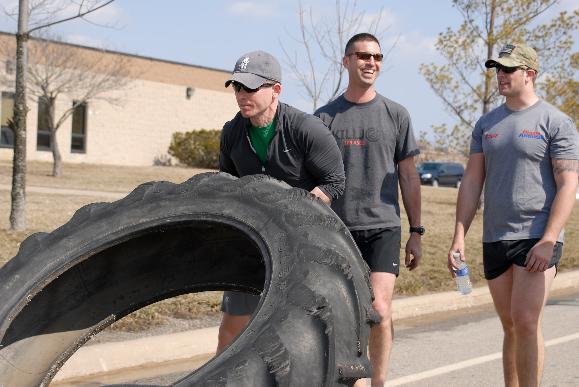 U.S. Air Force Capt. Daniel Curtin and fellow Tactical Air Control Party specialists flip a 230 pound tractor tire across the final lap of the TACP Association 24 Hour Run Challenge at the 182nd Airlift Wing in Peoria, Ill., March 29, 2013.  Sixty-two runners ran 161.75 miles around the installation over the course of 24 hours and raised over $8,200 in support of the TACP community and their families.  The 182nd team also ran in remembrance of Staff Sgt. Jacob Frazier, a member of the Peoria-based 169th Air Support Operations Squadron who was killed in action near Geresk, Afghanistan, exactly 10 years earlier.  (U.S. Air Force photo by Staff Sgt. Lealan Buehrer//Released)