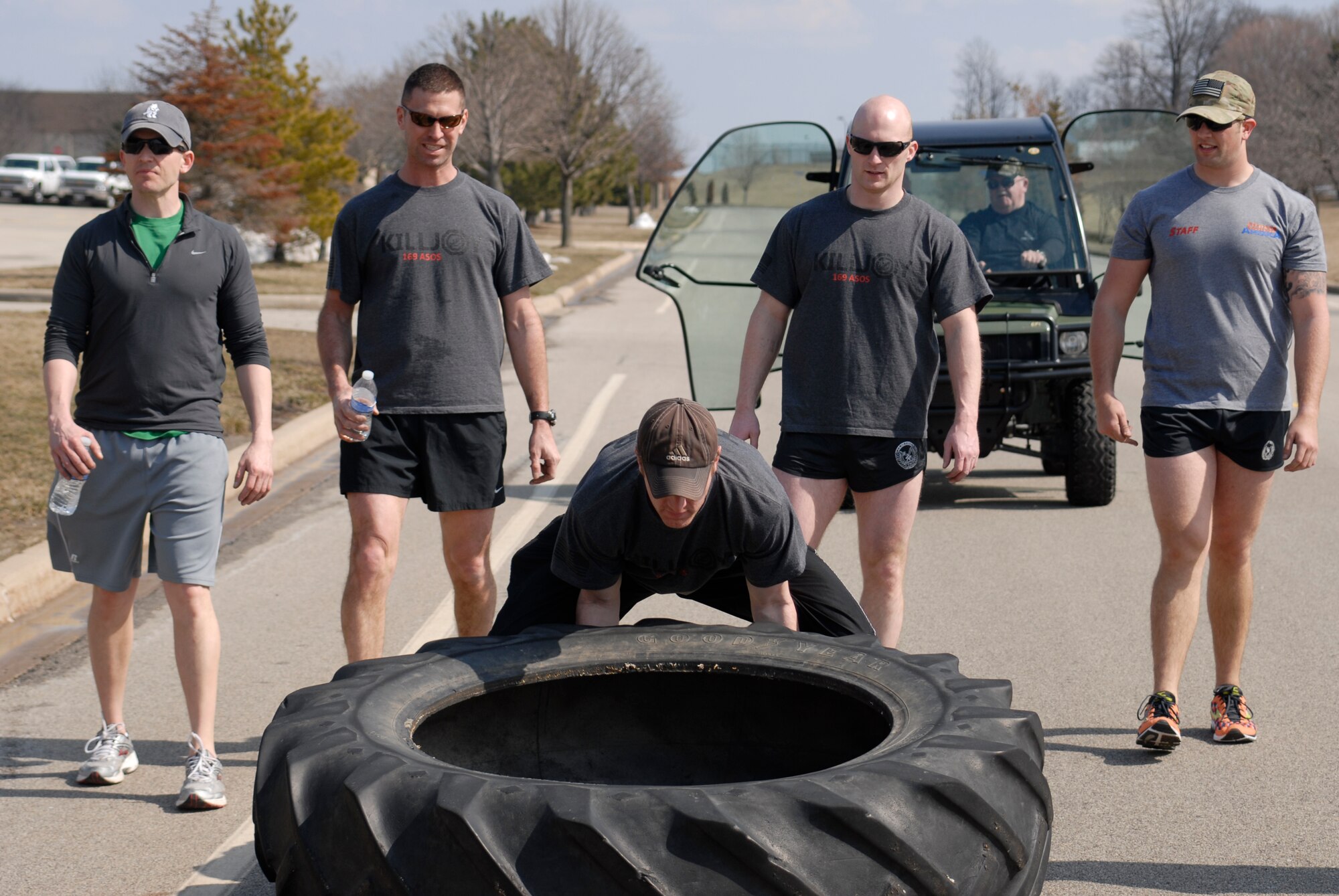 U.S. Air Force Senior Airman Cody Canfield and fellow Tactical Air Control Party specialists flip a 230 pound tractor tire across the final lap of the TACP Association 24 Hour Run Challenge at the 182nd Airlift Wing in Peoria, Ill., March 29, 2013.  Sixty-two runners ran 161.75 miles around the installation over the course of 24 hours and raised over $8,200 in support of the TACP community and their families.  The 182nd team also ran in remembrance of Staff Sgt. Jacob Frazier, a member of the Peoria-based 169th Air Support Operations Squadron who was killed in action near Geresk, Afghanistan, exactly 10 years earlier.  (U.S. Air Force photo by Staff Sgt. Lealan Buehrer//Released)(This image was cropped to emphasize the subject of the image.)