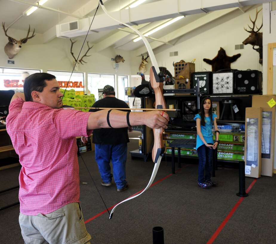 Tech. Sgt. Axel Gaud-Torres prepares to fire his bow at a range in Marysville Calif., March 29, 2013. His daughter Alexandria (right) overlooks her father on the archery range. (U.S. Air Force photo by Airman 1st Class Bobby Cummings/Released)