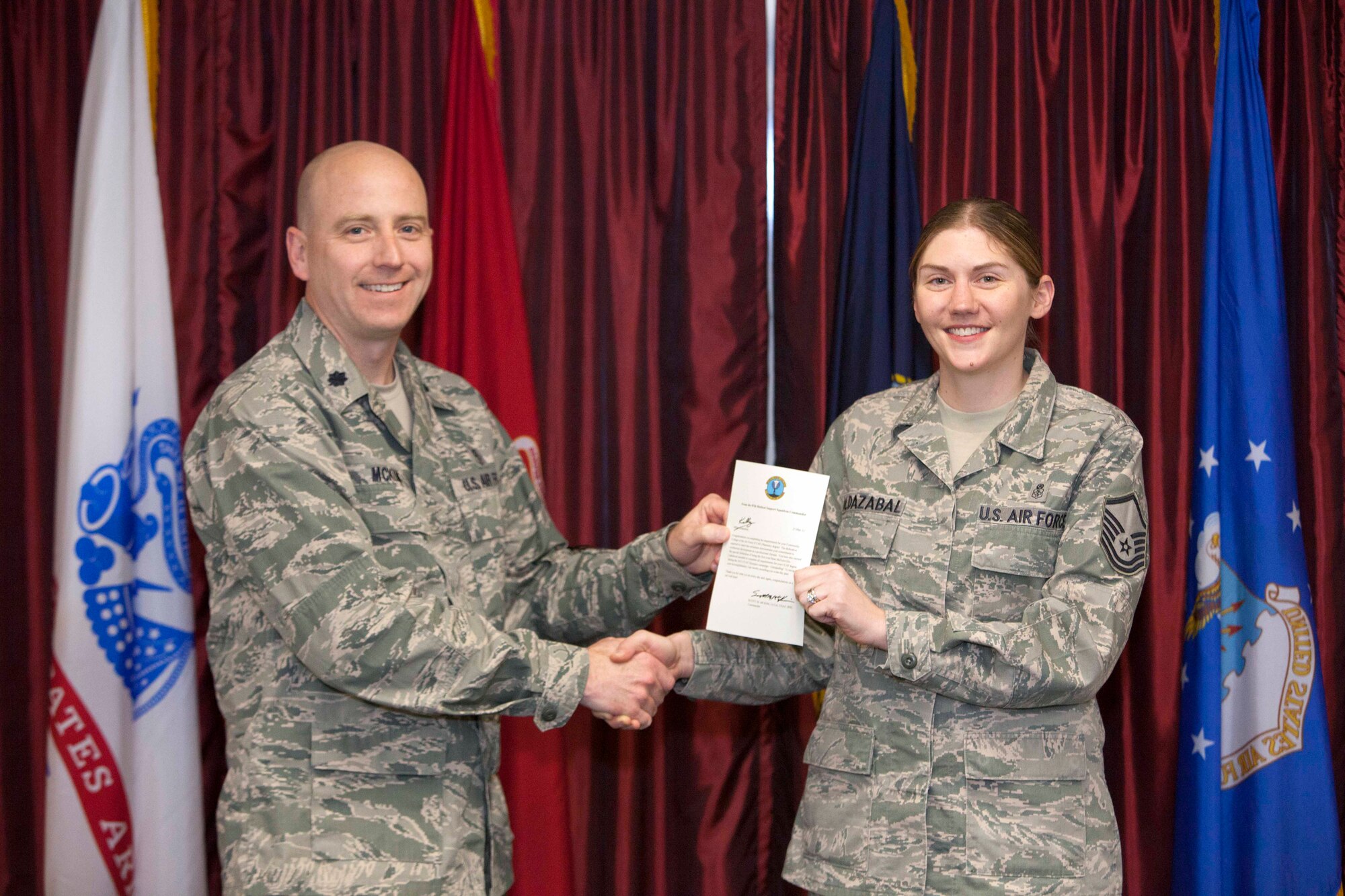 Lt. Col. Scott McKim, 87th Medical Support Squadron commander, presents Master Sgt. Kelly Aldazabal, 87th MDSS pharmacy support flight chief, with a certificate and one-day pass as the first Community College of the Air Force Olympics graduate March 28, 2013 at the Kish Airman Leadership Auditorium on Joint Base McGuire-Dix-Lakehurst, N.J. The JB MDL CCAF Olympics commenced March 1, 2013,and go through Aug. 31, 2013. The Olympics are designed to increase the percentage of enlisted personnel who have completed an Associate's degree over the Air Force and Air Mobility Command averages. Graduates are eligible to compete at both individual and unit levels, with individual awards being presented to the first graduate of each month of the competition and top three units in both large and small categories with the highest percentage of graduates at the CCAF commencement ceremony in the fall.  (U.S. Air Force photo by Wayne Russell/Released)
