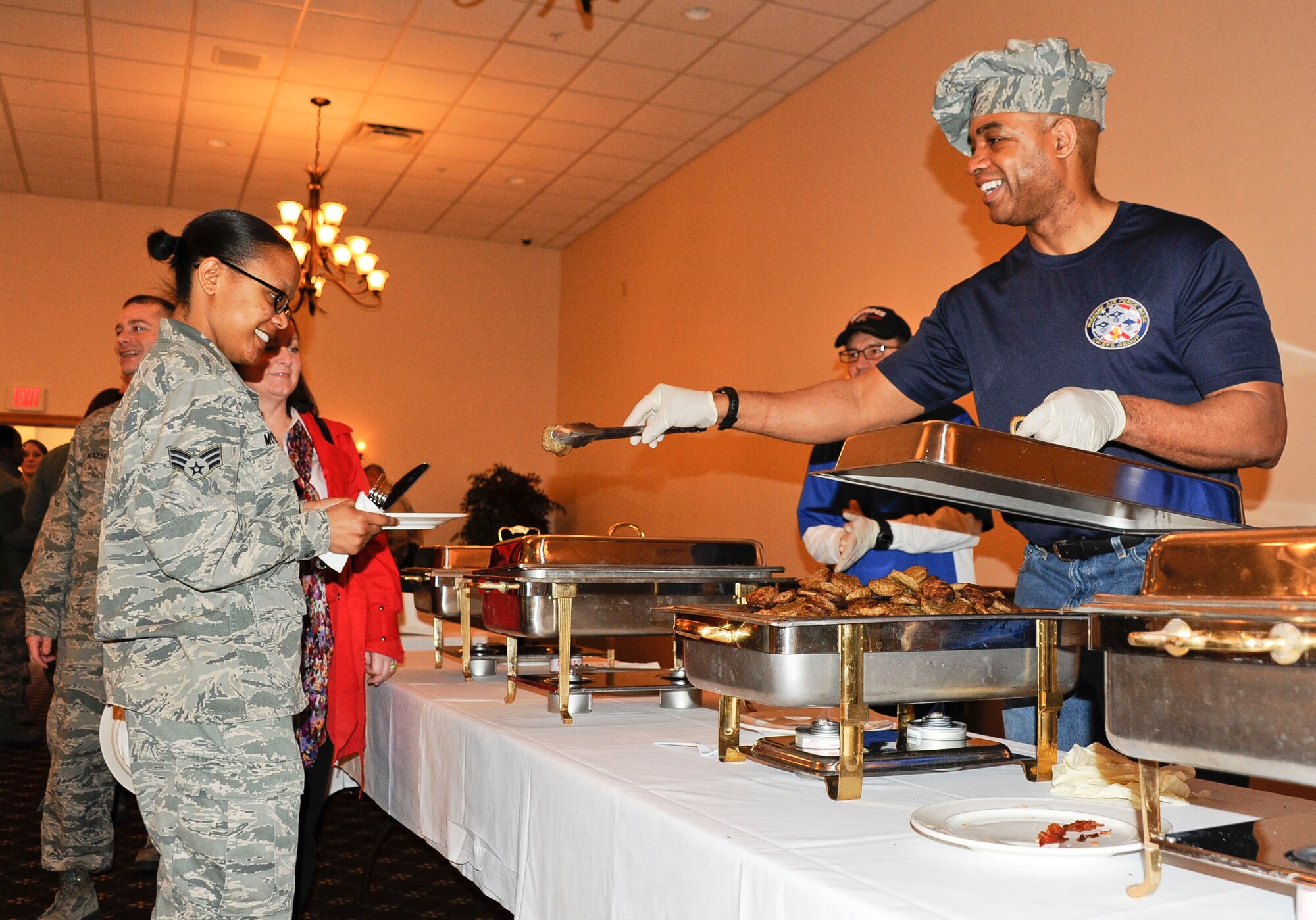 Chief Master Sgt. Vincent Burrell, 87th Command Post command and control functional manager, serves Senior Airman Latasha Mosely, 87th Air Base Wing command section Airman, breakfast sausage during the McGuire Chiefs’ Group Pancake Breakfast at Tommy B’s Community Activities Center, March 29, 2013. The money raised from the event will go to fun enlisted organizations. (U.S. Air Force photo by Airman 1st Class Ryan Throneberry/Released)
