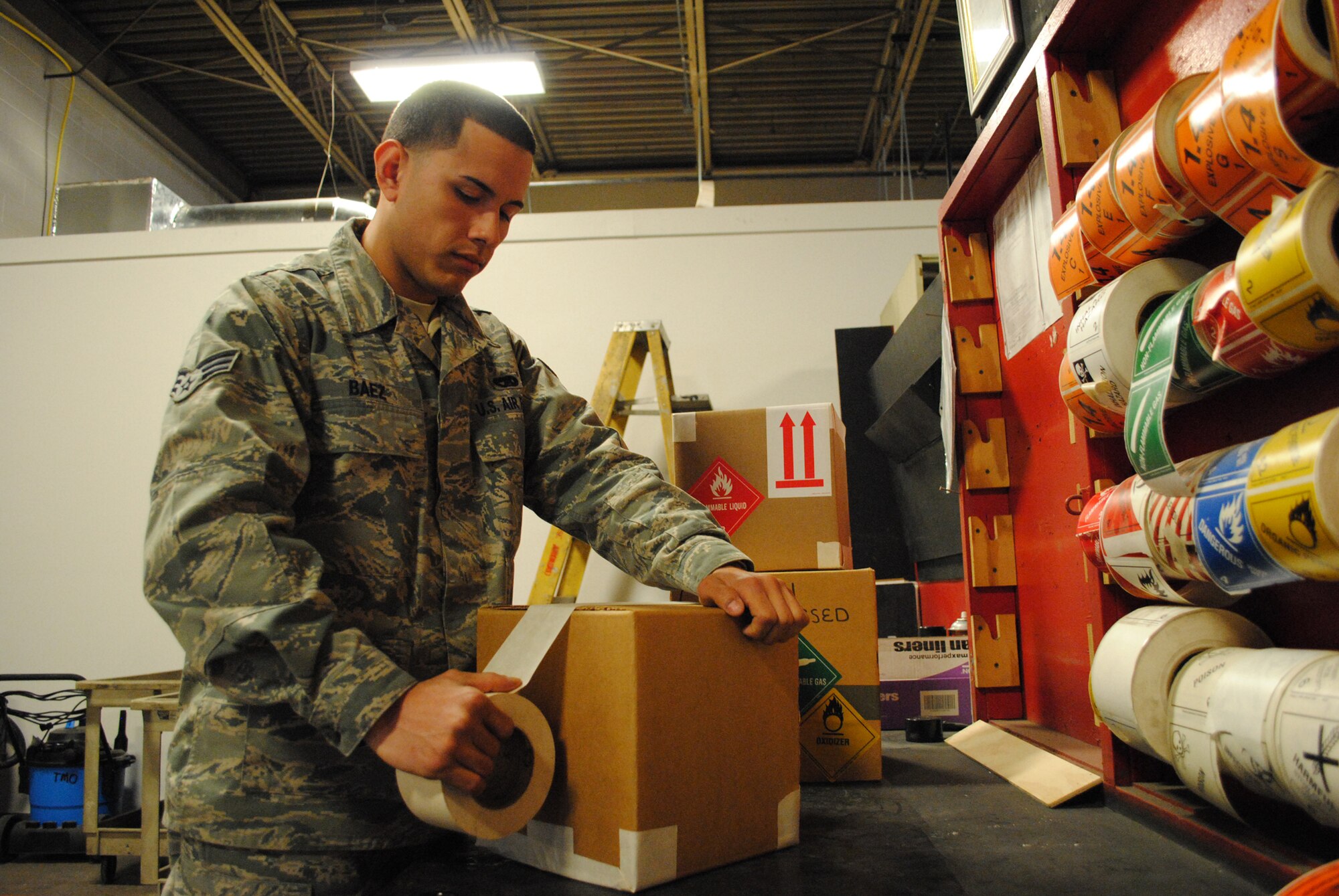 Senior Airman Nelson Baez, a cargo movement specialist with the 319th Logistics Readiness Squadron, preps a package for transport on April 4, 2013, at his work station at Grand Forks Air Force Base, N.D. Baez ensures all corners and openings on packages are sealed in order to prevent leaks and exposure to weather elements. (U.S. Air Force photo/Staff Sgt. Luis Loza Gutierrez)