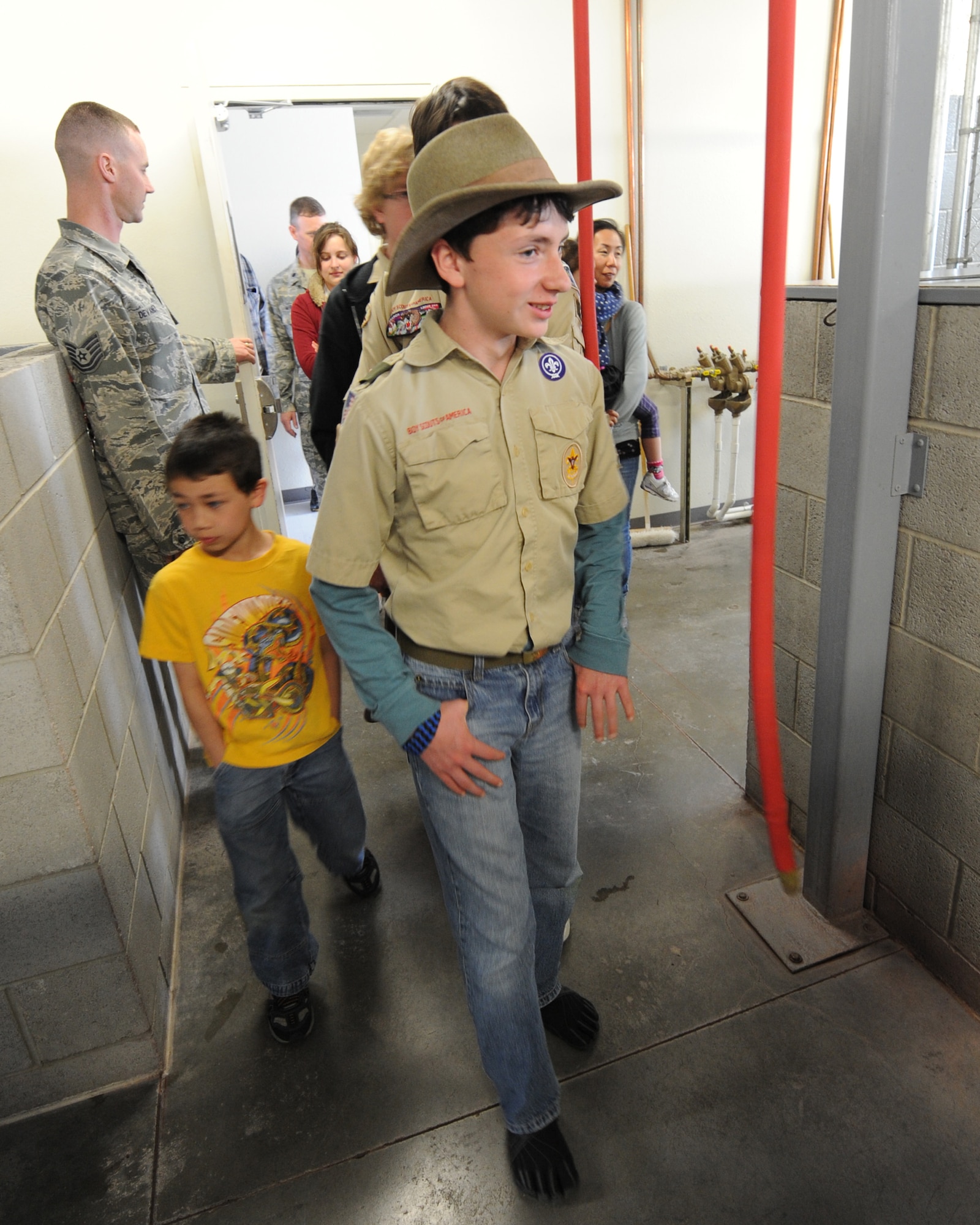 A Boy Scout walks past dog kennels during a tour of the 366th Security Forces Squadron military working dog unit at Mountain Home Air Force Base, Idaho, April 1, 2013. The kennel master, Tech. Sgt. Justin Devaney, led the tour to show how security forces Airmen take care of their canine counterparts. (U.S. Air Force photo/Airman 1st Class Malissa Lott)