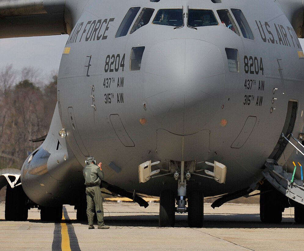 A crew chief for a C-17 Globemaster III from Joint Base Charleston, Sc. performs pre-flight operations before departing Joint Base Andrews, Md., Apr. 2, 2013.Team Andrews members run one of the most international-known flight lines in the military. Supporting missions affecting global operations, as well as being the home of Air Force One. (U.S Air Force photo/Staff Sgt. Perry Aston)