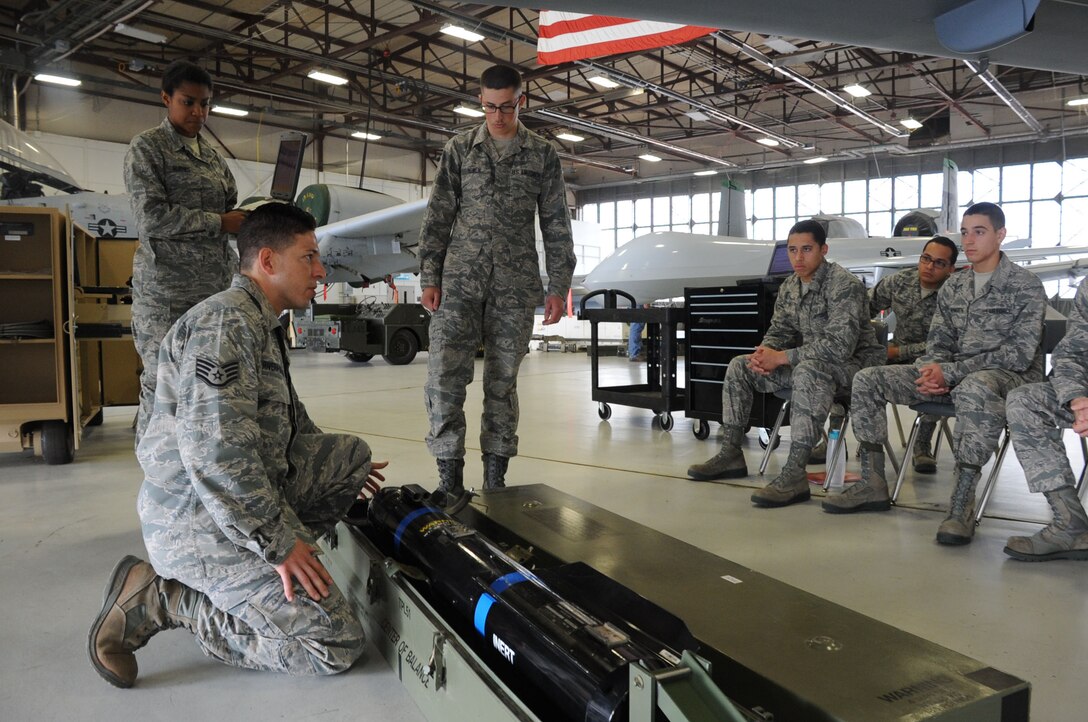 Staff. Sgt. Ronel Rivera-Santiago (left fore), 363rd Training Squadron Aircraft Armament Instructor for the new Remotely Piloted Aircraft armament course, gives a lecture to students on how to upload the AGM-114 Hellfire missile to the MQ-9A Reaper during class at Sheppard Air Force Base, Texas, April 4, 2013.  The RPA armament course will graduate its first students April 8.  (U.S. Air Force photo/Dan Hawkins) 
