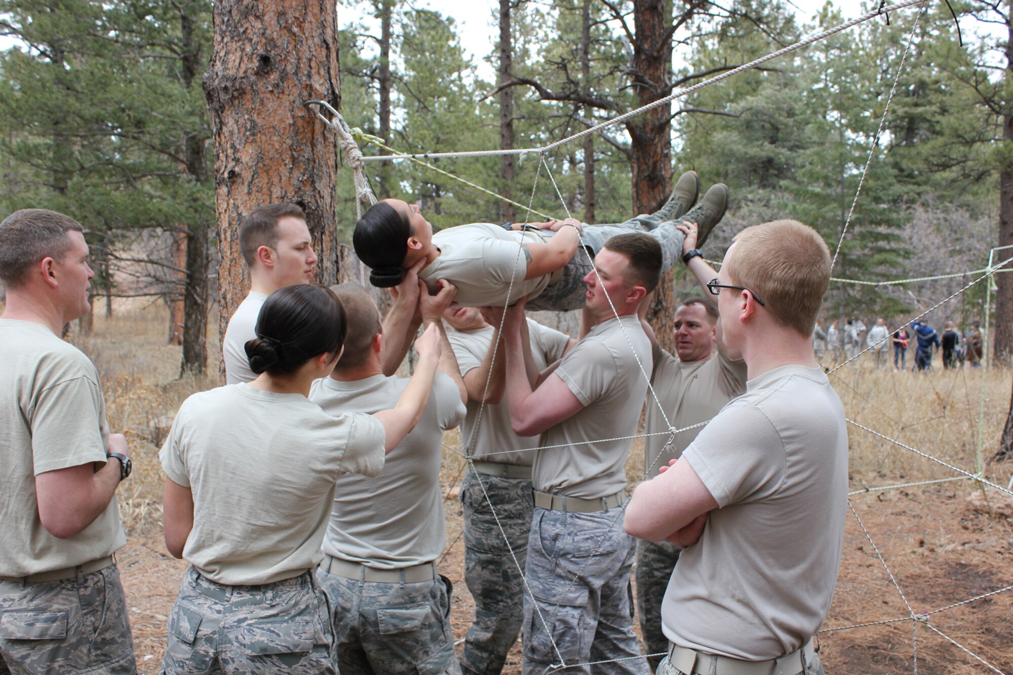 Airmen from the 21st Communications Squadron work through obstacles March 28 at the ropes course at the Air Force Academy.  The 21st Space Wing held its Wingman Day to highlight the four pillars of wellness, which are physical, mental, social and spiritual fitness. (U.S. Air Force photo)