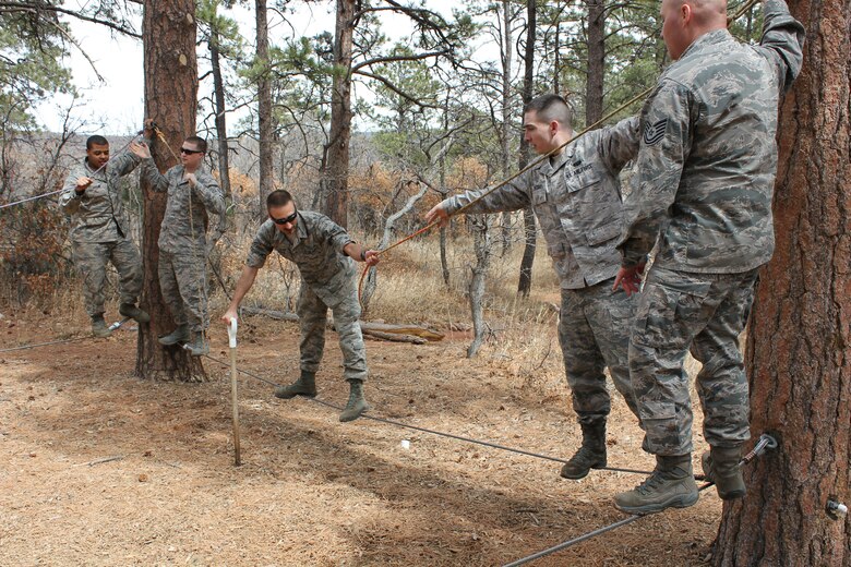 Airmen from the 21st Communications Squadron work through obstacles March 28 at the ropes course at the Air Force Academy.  The 21st Space Wing held its Wingman Day to highlight the four pillars of wellness, which are physical, mental, social and spiritual fitness. (U.S. Air Force photo)