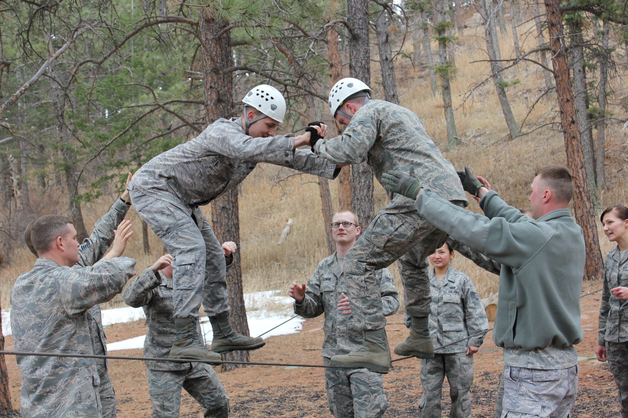 Airmen from the 21st Communications Squadron work through obstacles March 28 at the ropes course at the Air Force Academy.  The 21st Space Wing held its Wingman Day to highlight the four pillars of wellness, which are physical, mental, social and spiritual fitness. (U.S. Air Force photo)