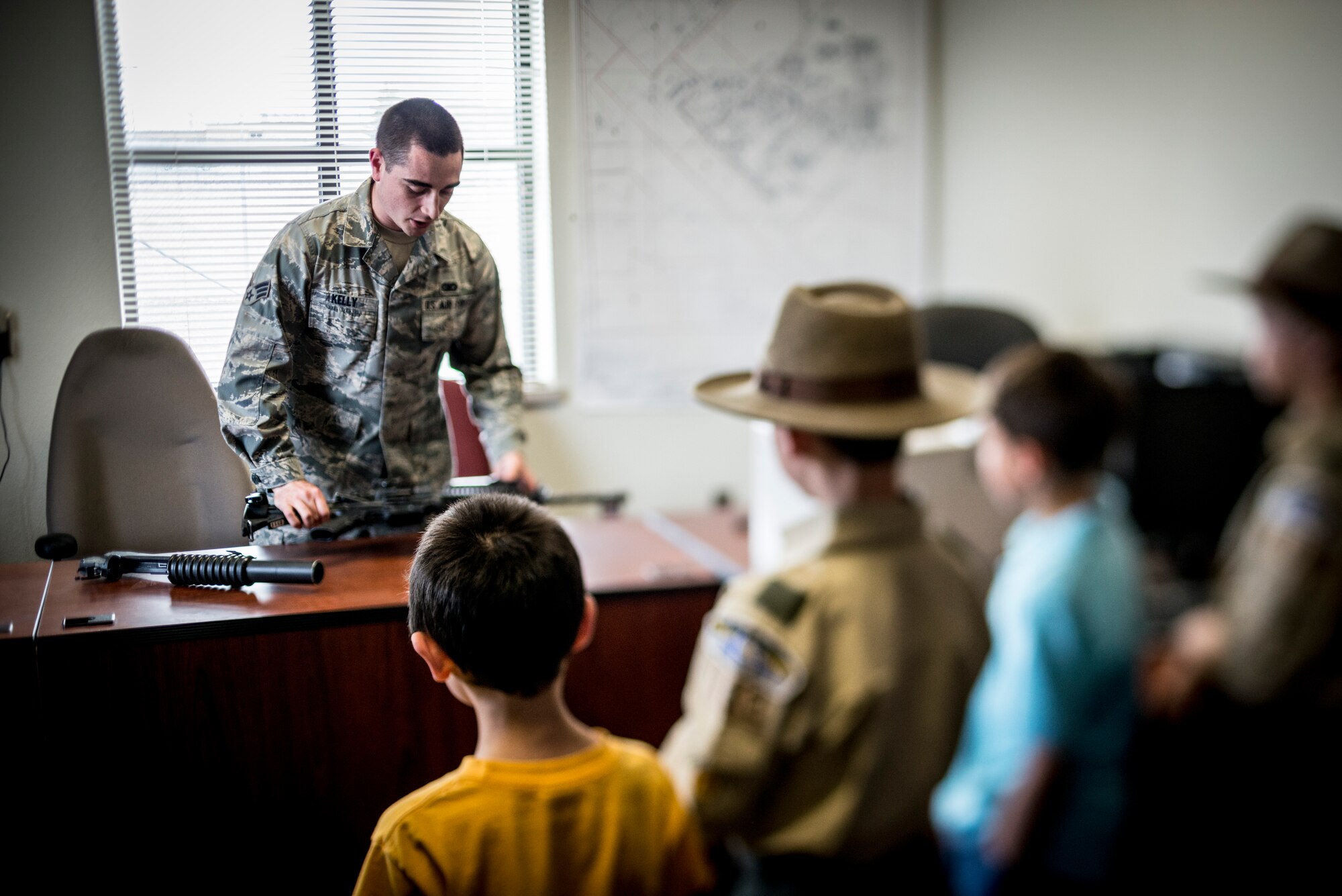 U.S. Air Force Senior Airman Jordan Kelly, 366th Security Forces Squadron assistant NCO in charge of the armory, talks to Boy Scout Troop 102 at the 366 SFS military working dog kennel at Mountain Home Air Force Base, Idaho, April 1, 2013. Kelly talked about different weapons used by security forces Airmen. (U.S. Air Force photo/Tech. Sgt. Samuel Morse)