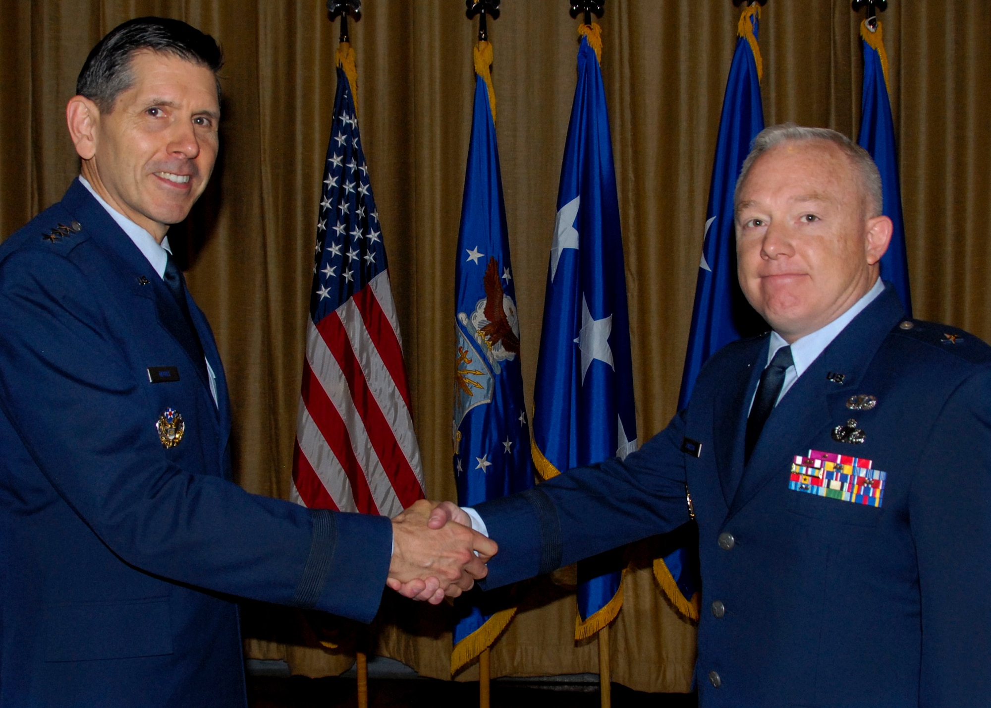 Brig. Gen. Scott Jansson, right, accepts the position of Air Force Program Executive Officer for Weapons from Lt. Gen. C.D. Moore II, commander, Air Force Life Cycle Management Center, Wright-Patterson Air Force Base, Ohio during an official ceremony April 4.  Maj. Gen. Kenneth Merchant, the former PEO, will transfer to the Office of the Assistant Secretary of the Air Force for Acquisition, Headquarters U.S. Air Force, Washington, D.C., to become the director of global reach programs.  Jansson comes to Eglin after serving almost two years as the commander of Defense Logistic Agency Aviation, a field activity of the DLA. headquartered in Richmond, Va.  The PEO will work at the Armament Directorate here, a unit who reports to the Secretary of the Air Force for Acquisition, Washington, D.C. and AFLCMC. The directorate is responsible for enhancing worldwide Air Force combat capability, effectiveness, aircrew survivability, and readiness through joint development, test, procurement, deployment and sustainment of air delivered weapon systems.  (U.S. Air Force photo/ Kevin Gaddie)