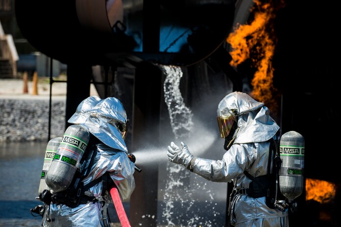 Members from the 628th Civil Engineer Squadron receive instructions as they spray water on a fire during an aircraft, live-fire training exercise March 29, 2013, at Joint Base Charleston – Air Base, S.C. The base performs quarterly aircraft, live-fire training for firefighters and crew chiefs to maintain their qualifications. (U.S. Air Force photo/ Senior Airman George Goslin)