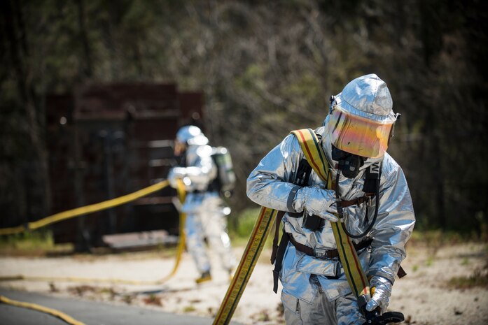 A member from the 628th Civil Engineer Squadron drags a fire hose into position during an aircraft, live-fire training exercise March 29, 2013, at Joint Base Charleston – Air Base, S.C. The base performs quarterly aircraft, live-fire training for firefighters and crew chiefs to maintain their qualifications. (U.S. Air Force photo/ Senior Airman George Goslin)